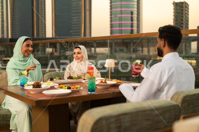 Arab Friends Dining on Dubai Rooftop at Sunset