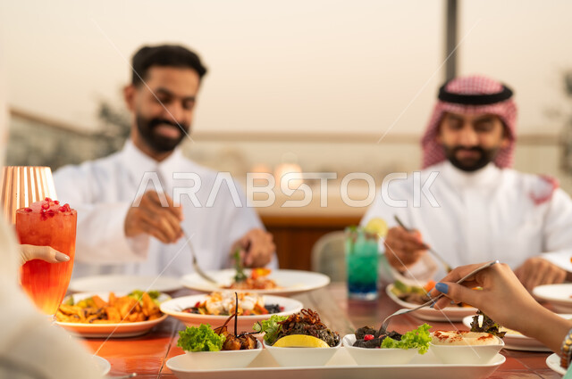 رجال سعوديون يتناولون الطعام في مطعم خارجي