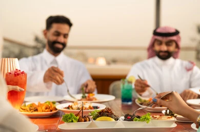 رجال سعوديون يتناولون الطعام في مطعم خارجي