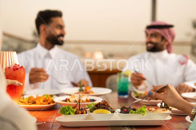 رجال سعوديون يتناولون الطعام في الخارج وقت الغروب