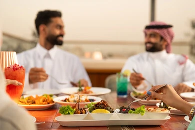 رجال سعوديون يتناولون الطعام في الخارج وقت الغروب