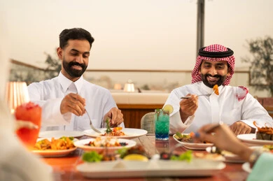 Saudi Men Dining at Rooftop Restaurant Sunset