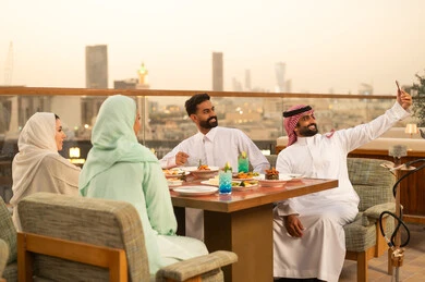 أصدقاء سعوديون يتناولون العشاء في مطعم بالرياض وقت الغروب أصدقاء سعوديون يتناولون العشاء في مطعم بالرياض وقت الغروب