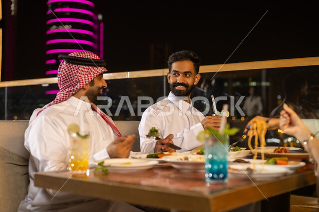 Saudi Men Dining at Night Rooftop Restaurant