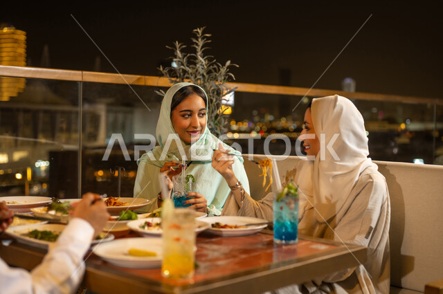 Arab Women Dining at Rooftop Restaurant Night
