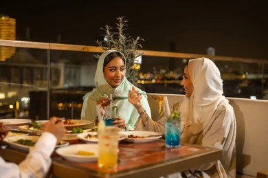 نساء عربيات في مطعم خارجي ليلاً
