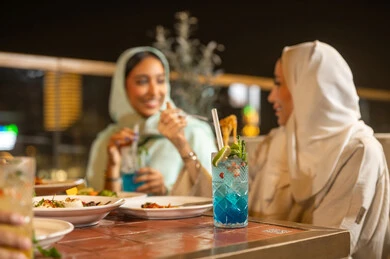 Khaleeji Women Dining at Outdoor Restaurant at Night