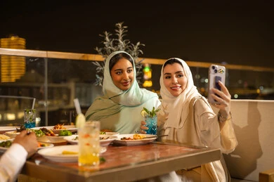 Arab Women Taking Selfie at Rooftop Restaurant Night