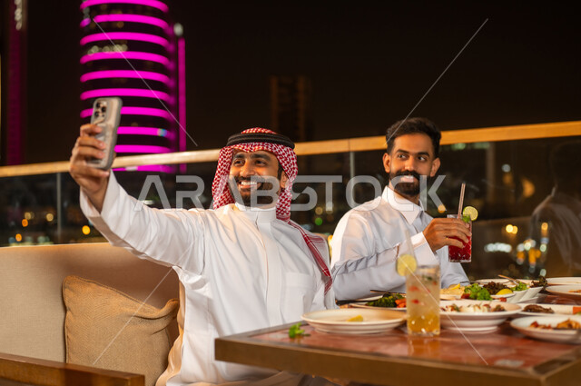 Saudi Men Taking Selfie at Rooftop Restaurant Night