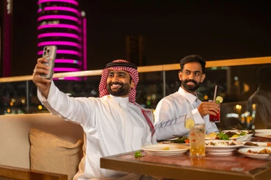 Saudi Men Taking Selfie at Rooftop Restaurant Night
