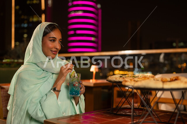 Saudi Woman at Rooftop Restaurant Night City View
