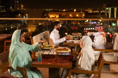 أصدقاء سعوديون في مطعم على السطح ليلاً أصدقاء سعوديون في مطعم على السطح ليلاً