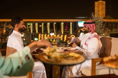 Saudi Men Dining at Rooftop Restaurant Night