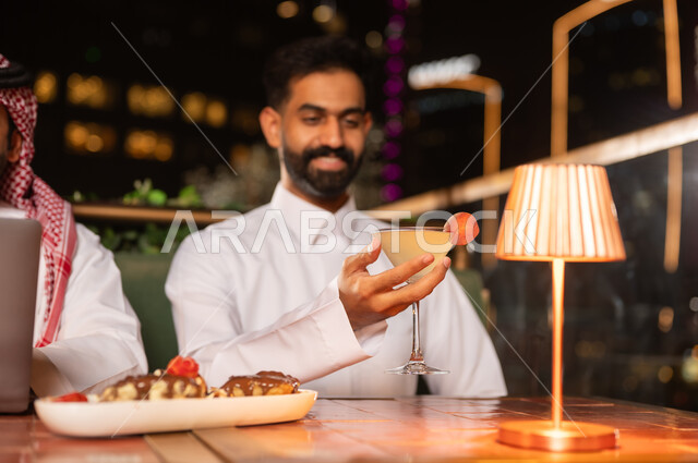 رجل عربي في مطعم خارجي على السطح ليلاً
