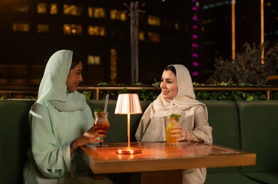Arab Women at Night Rooftop Lounge with City Lights
