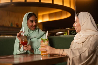 نساء عربيات محجبات في مطعم يتناولن المشروبات