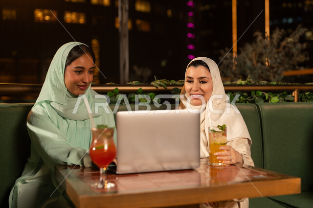Arab Women Using Laptop at Outdoor Restaurant Night
