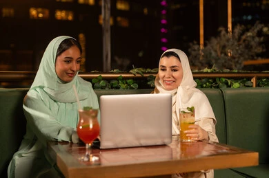 Arab Women Using Laptop at Outdoor Restaurant Night