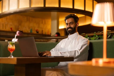 Saudi Man Using Laptop in Modern Restaurant