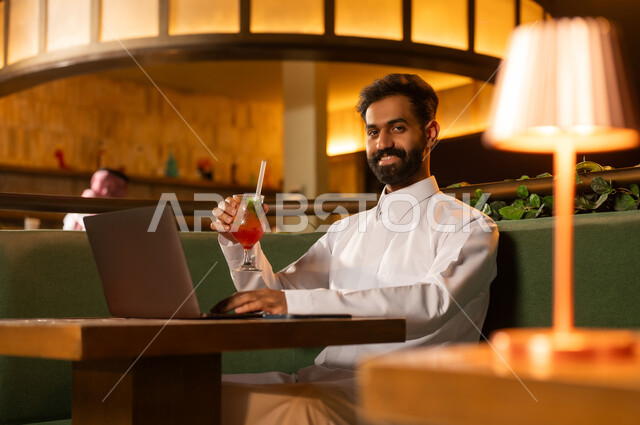 رجل أعمال سعودي مع لابتوب في ردهة دافئة