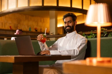 Saudi Businessman with Laptop in Warm Lounge Setting