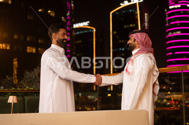 Saudi Businessmen Shaking Hands in Riyadh at Night