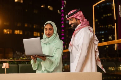 Saudi Business Couple Working on Laptop at Night