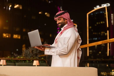 Saudi Businessman Using Laptop at Night Outdoors