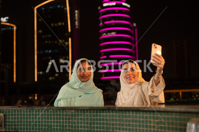 نساء خليجيات يلتقطن سيلفي مع أفق المدينة ليلاً