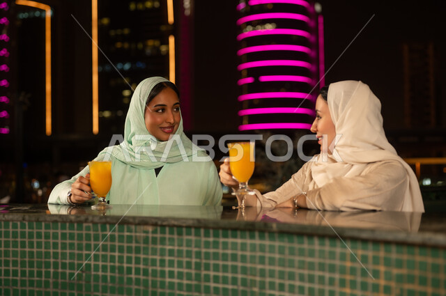 نساء خليجيات يشربن العصير في المدينة ليلاً