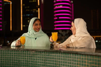 نساء خليجيات يشربن العصير في المدينة ليلاً