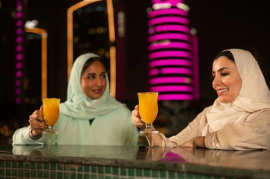 نساء سعوديات مع عصير برتقال في إطلالة ليلية