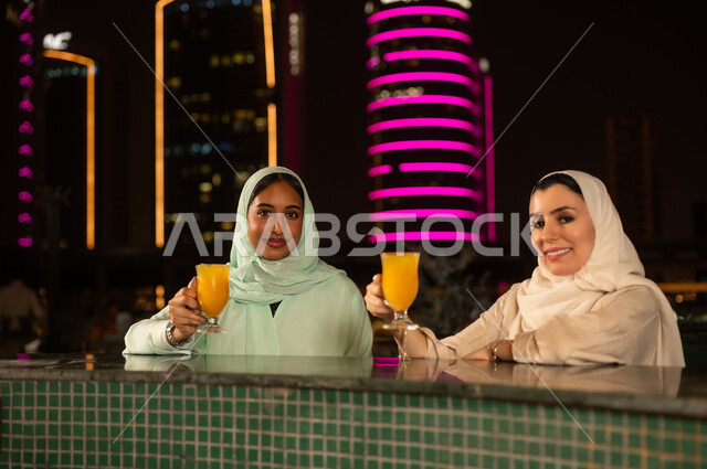 سيدات سعوديات مع مشروبات في سطح بالرياض ليلا