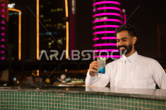 رجل عربي مع مشروب بارد في جلسة ليلية