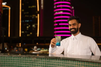 رجل سعودي مع مشروب بارد في مطعم ليلي