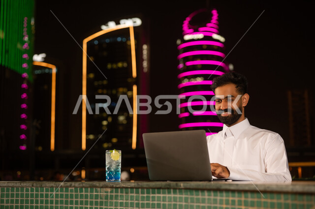 Saudi Businessman Working on Laptop at Night in City