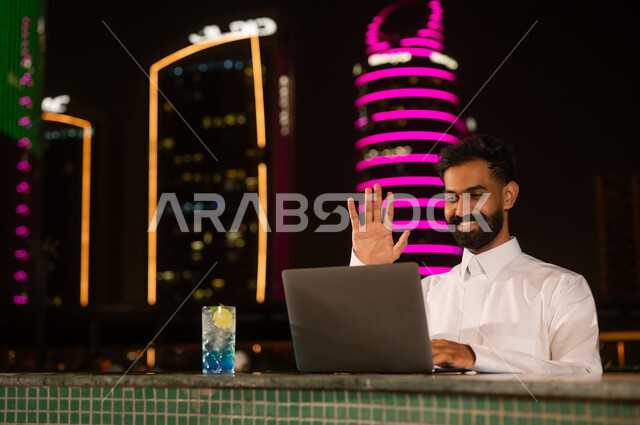 رجل سعودي يستخدم اللابتوب ليلاً في المدينة