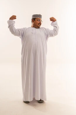 رجل عماني بالزي التقليدي يستعرض عضلاته