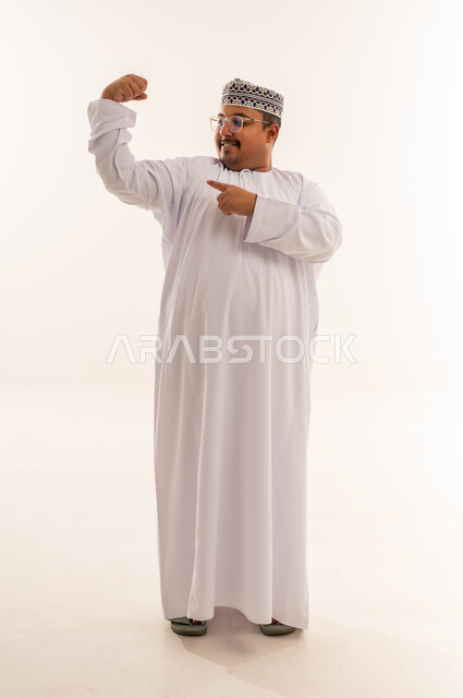 رجل عماني يستعرض عضلاته بالزي التقليدي