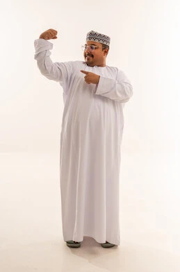 رجل عماني يستعرض عضلاته بالزي التقليدي