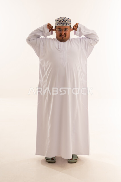 Omani Man Covering Ears in Traditional Dress Studio