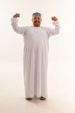 رجل عماني بالزي التقليدي يستعرض عضلاته في الاستوديو
