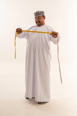 رجل عماني مع شريط قياس على خلفية بيضاء