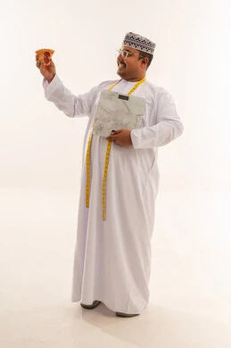 رجل عماني بوزن زائد مع ميزان وقطعة بيتزا بخلفية بيضاء