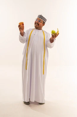 رجل عماني يختار بين البيتزا والفاكهة من أجل الرجيم