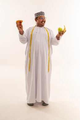 رجل عماني بدين يختار بين البيتزا والفواكه