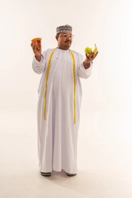 رجل عماني بوزن زائد يختار بين البيتزا والفاكهة