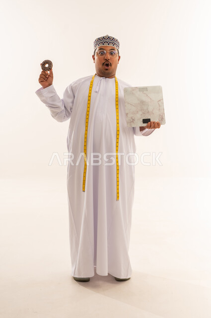 رجل عماني مع ميزان ودونات في الاستوديو