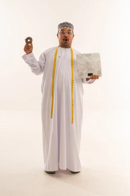 رجل عماني مع ميزان ودونات في الاستوديو