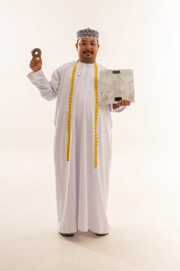 رجل عماني مع ميزان ودونات لمفهوم الصحة والسمنة